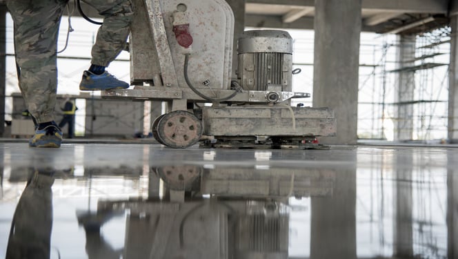 Construction worker produces the grout and finish wet concrete with a special tool. Float blades. For smoothing and polishing concrete, concrete floors